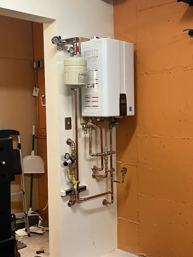 Plumbing technician inspecting water heater connections in Black Mountain